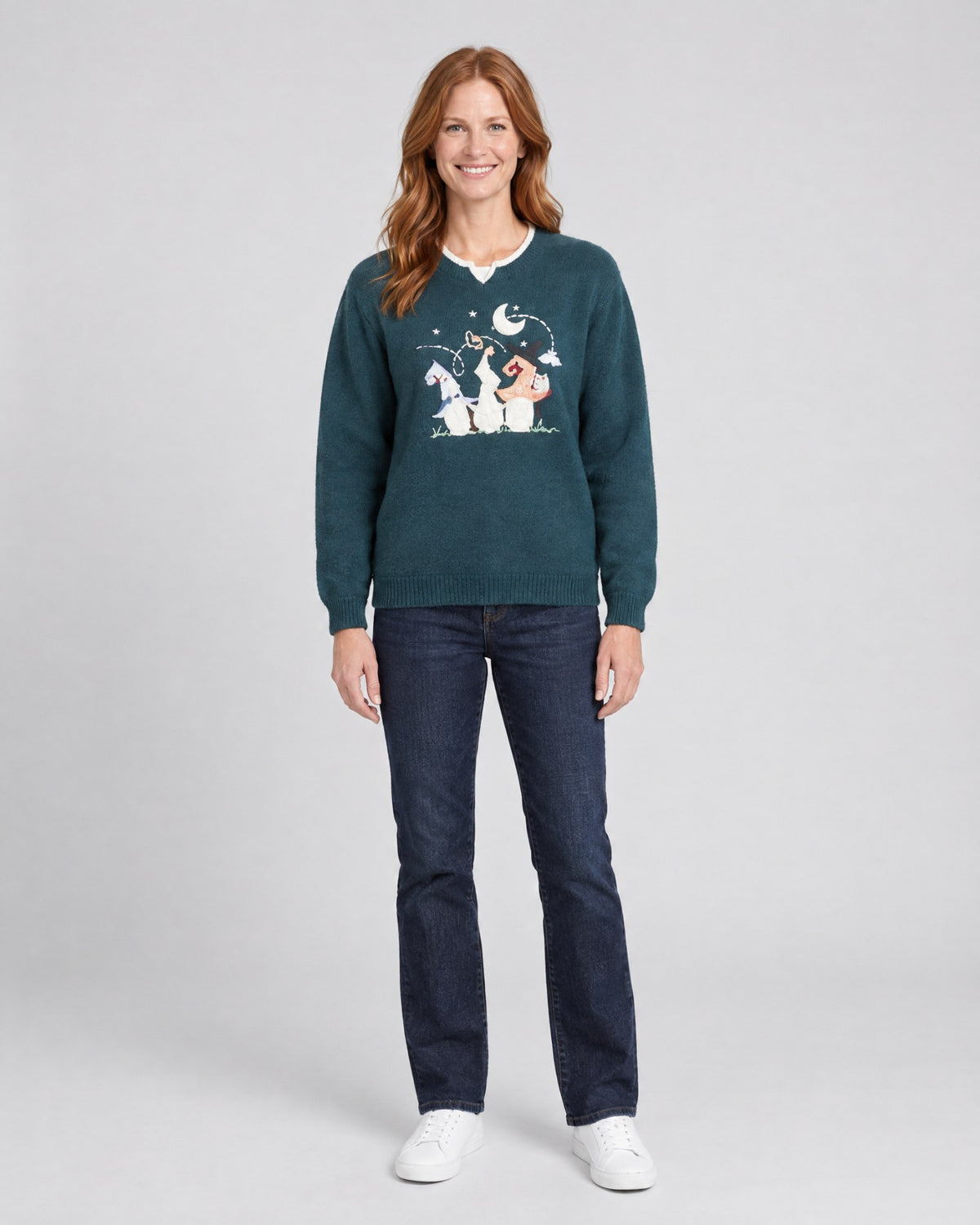 Model wearing a vintage Halloween ugly sweater with a pumpkin in a witch hat